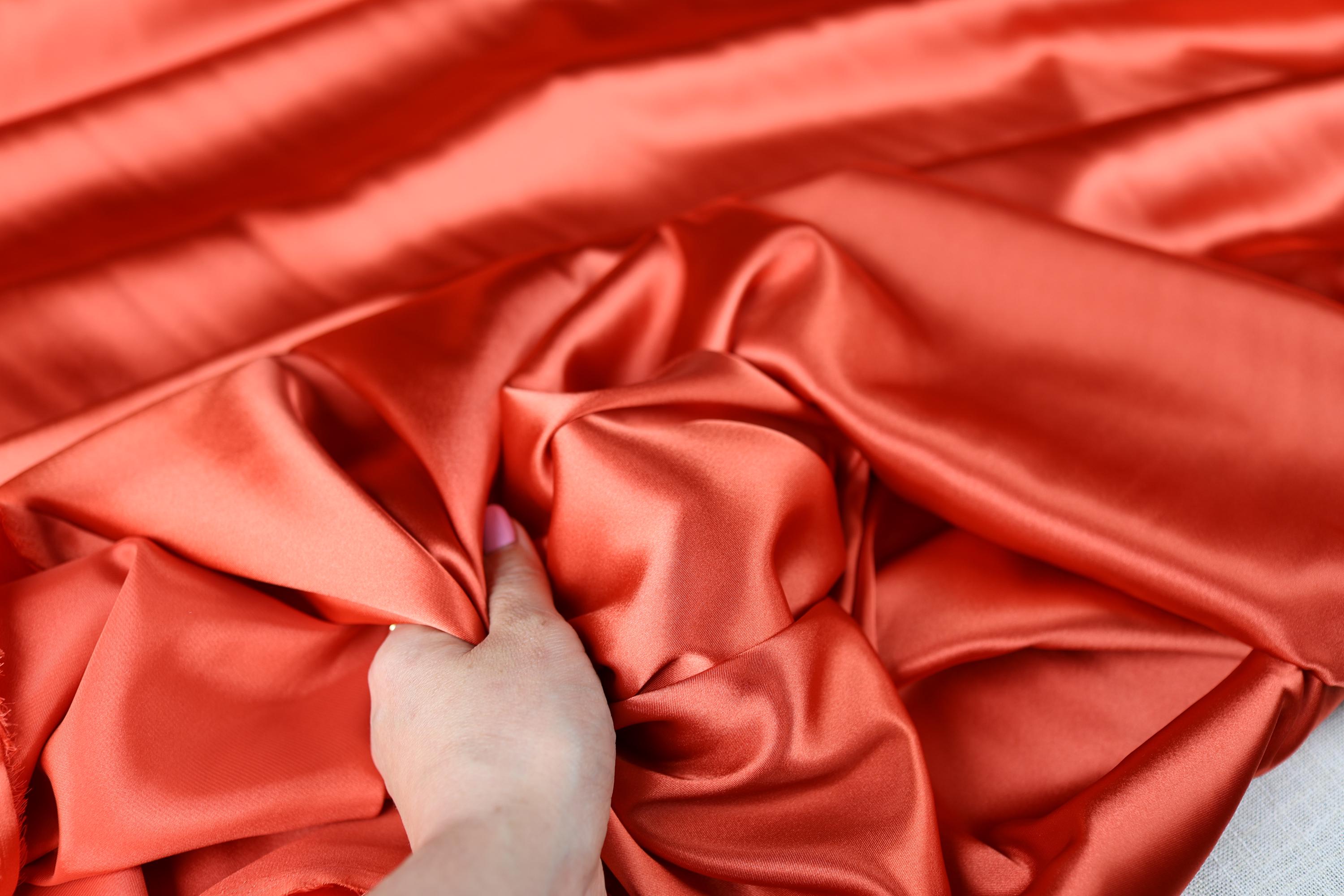 a person with their hand on a red cloth