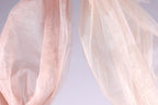 two pieces of light pink fabric, one on the left and one on the right, with a light purple background.