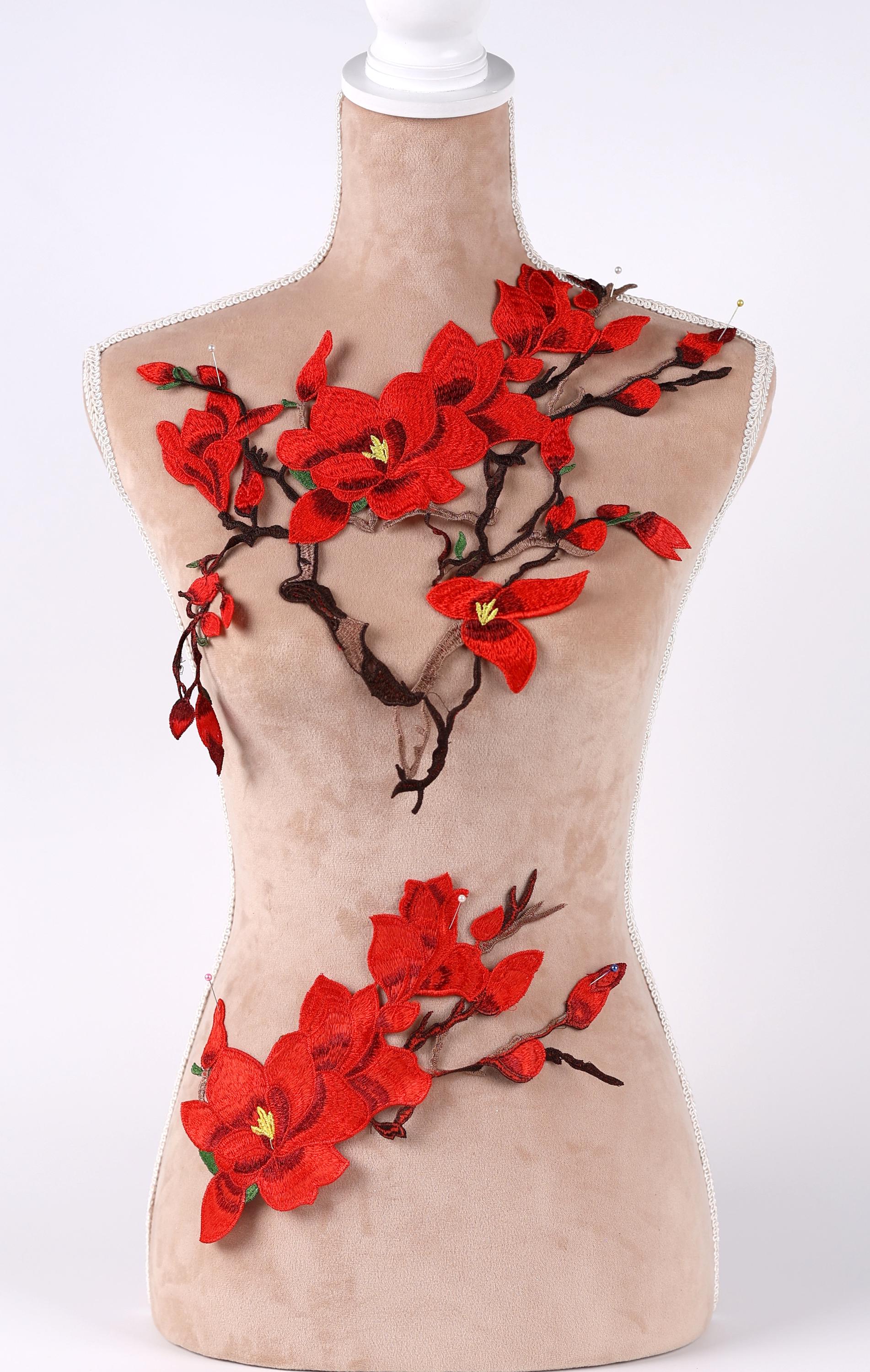 A mannequin with red flowers and branches attached to it, creating a decorative and artistic display.