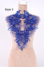 A mannequin wearing a blue lace collar with intricate floral patterns.