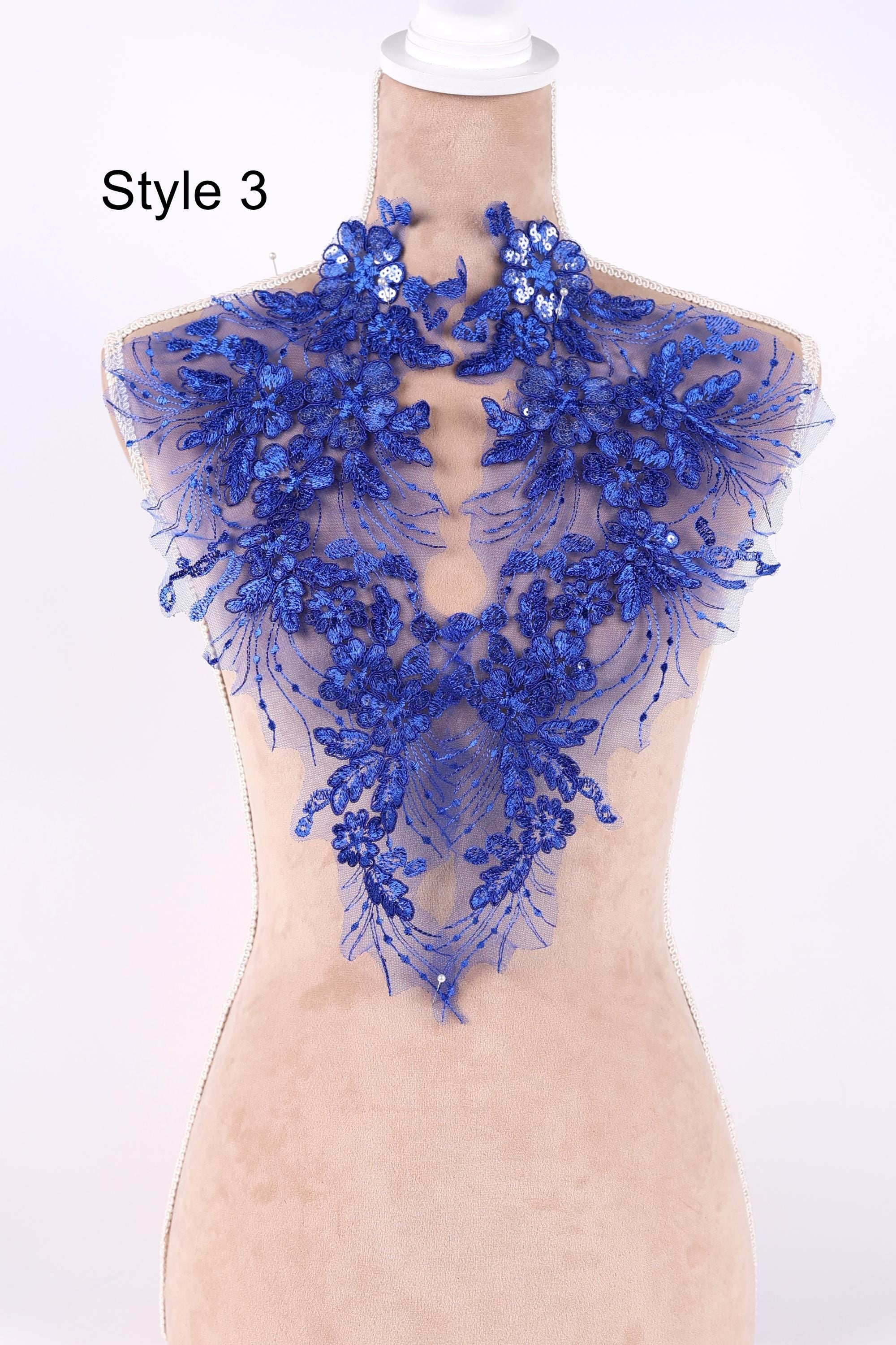 A mannequin wearing a blue lace collar with intricate floral patterns.