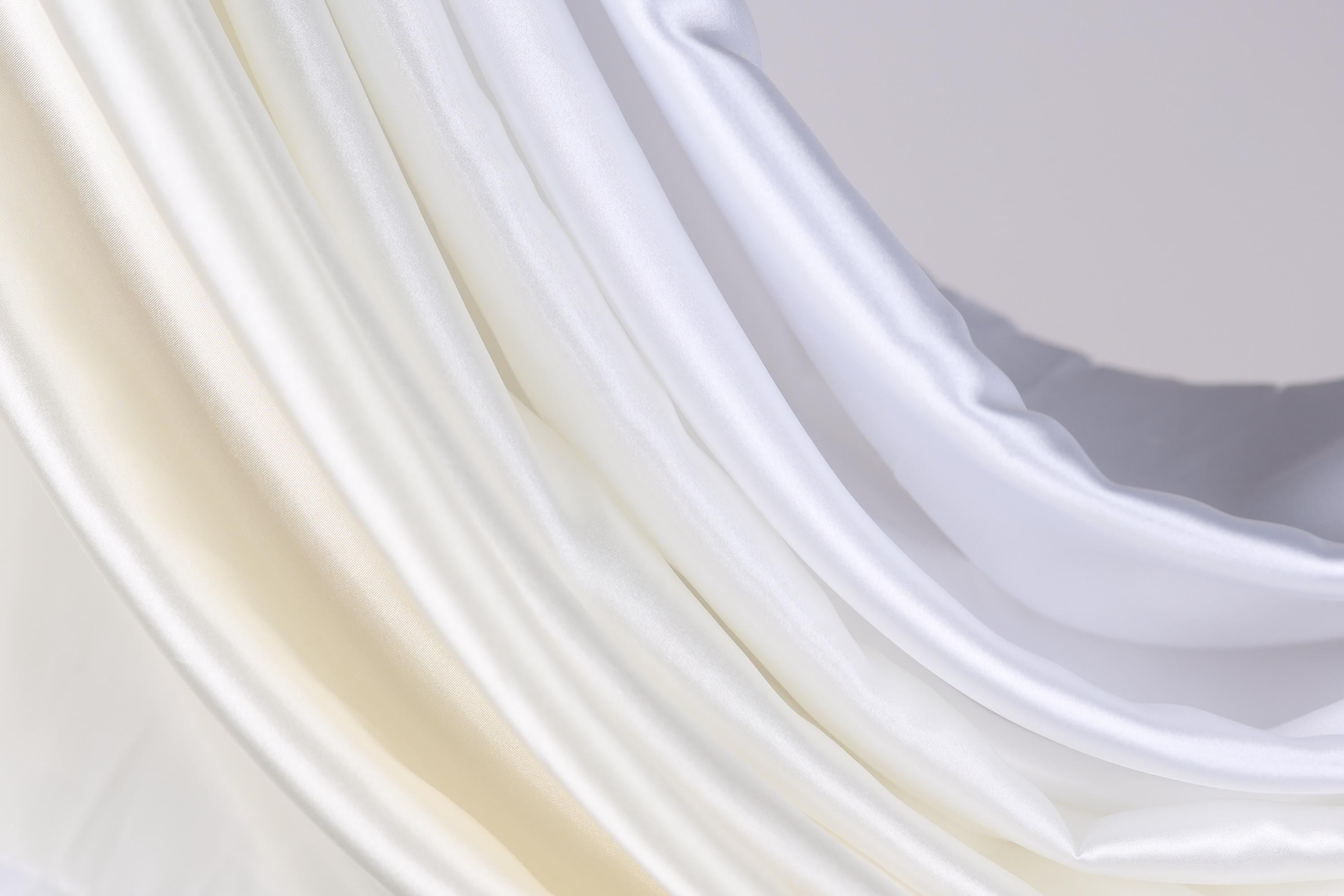 a close up of a white curtain with a white background