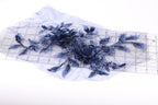 a close-up view of a blue floral embroidery on a piece of fabric, with a ruler visible in the background.