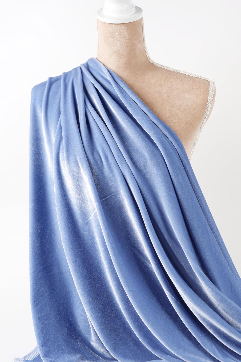 A mannequin wearing a blue draped fabric draped over its body.