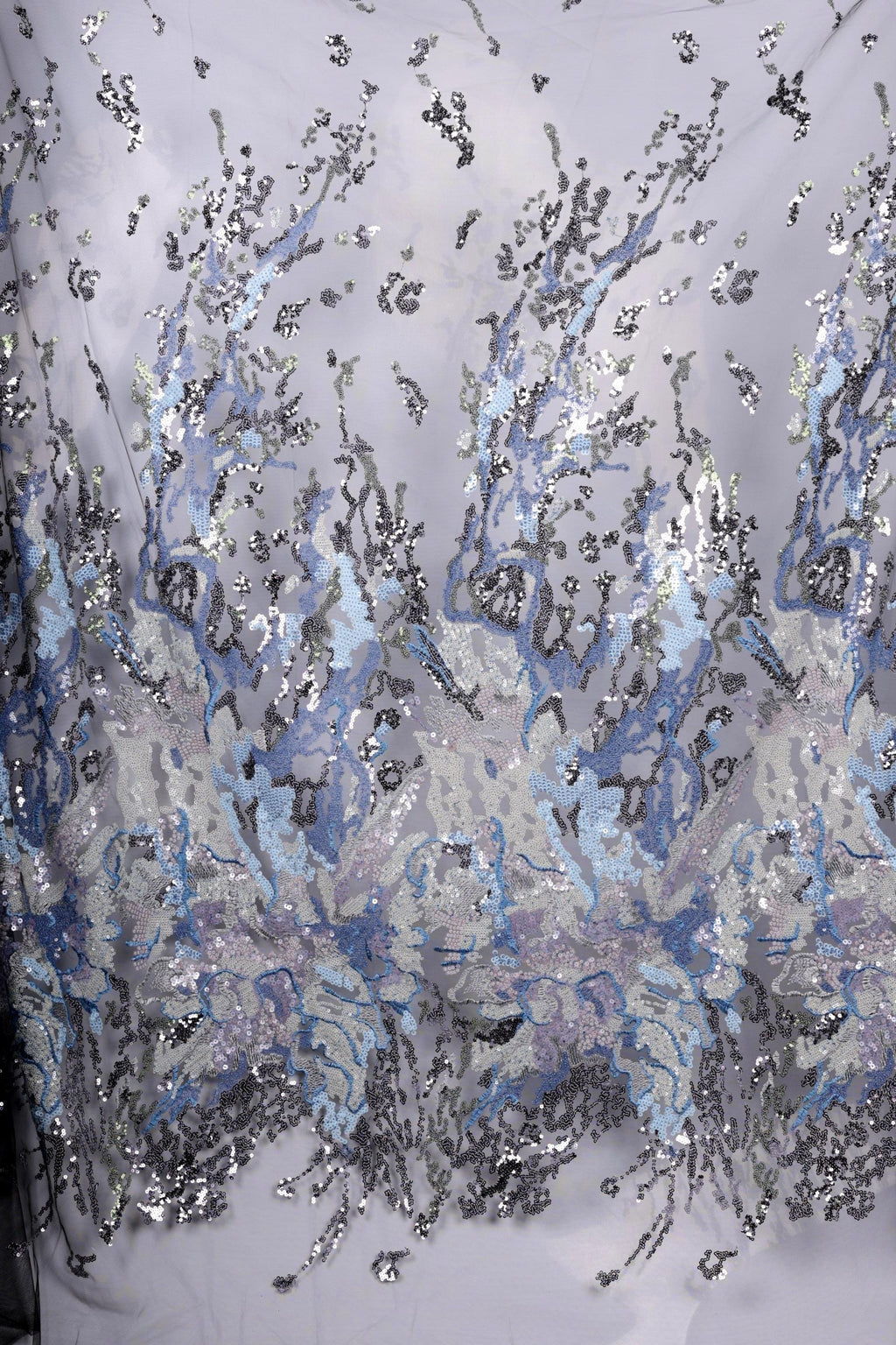 a fabric with a striking pattern of blue and silver sequins, creating a visually captivating and intricate design.