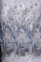 a fabric with a striking pattern of blue and silver sequins, creating a visually captivating and intricate design.