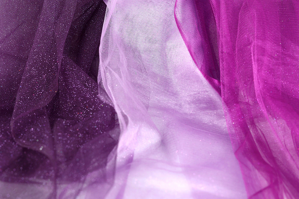 a close-up view of a fabric with a purple and white color scheme, with the purple fabric appearing more prominent.