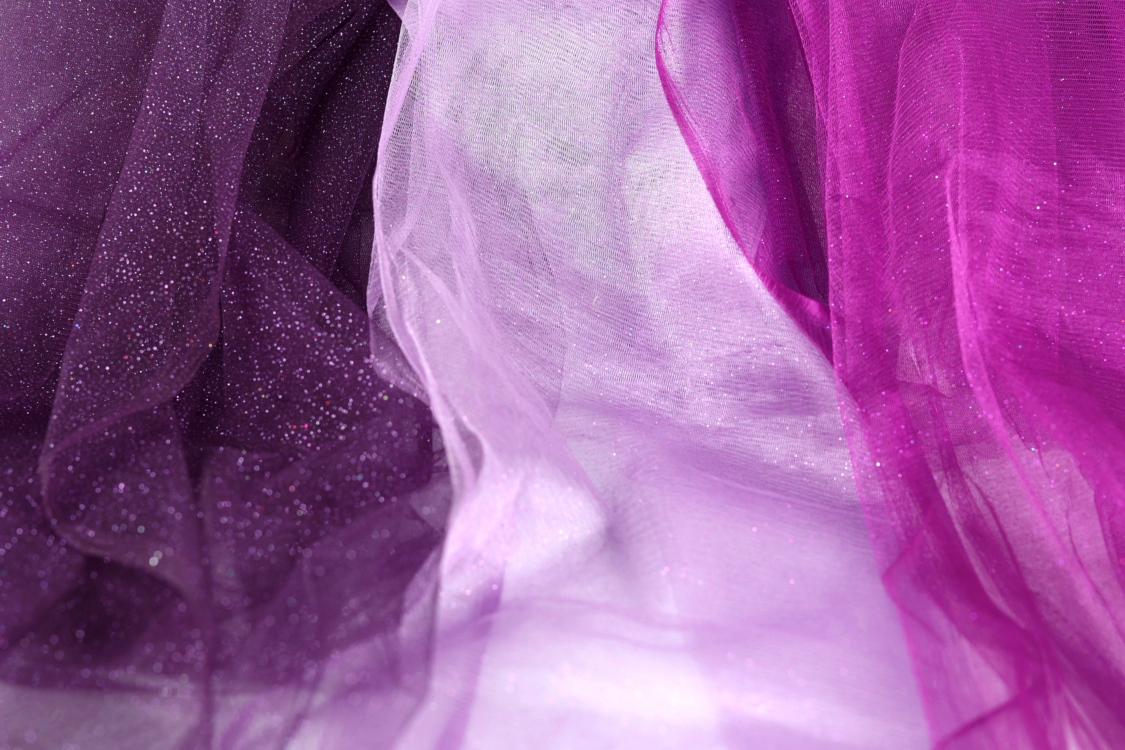 a close-up view of a fabric with a purple and white color scheme, with the purple fabric appearing more prominent.