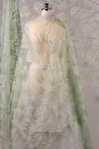 a fabric with a floral pattern, including white and green flowers, and a sheer, transparent overlay.