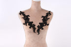 A mannequin with black lace or floral embroidery on its shoulders.