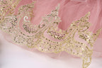 a close-up view of a delicate, pink tulle skirt adorned with intricate gold embroidery.