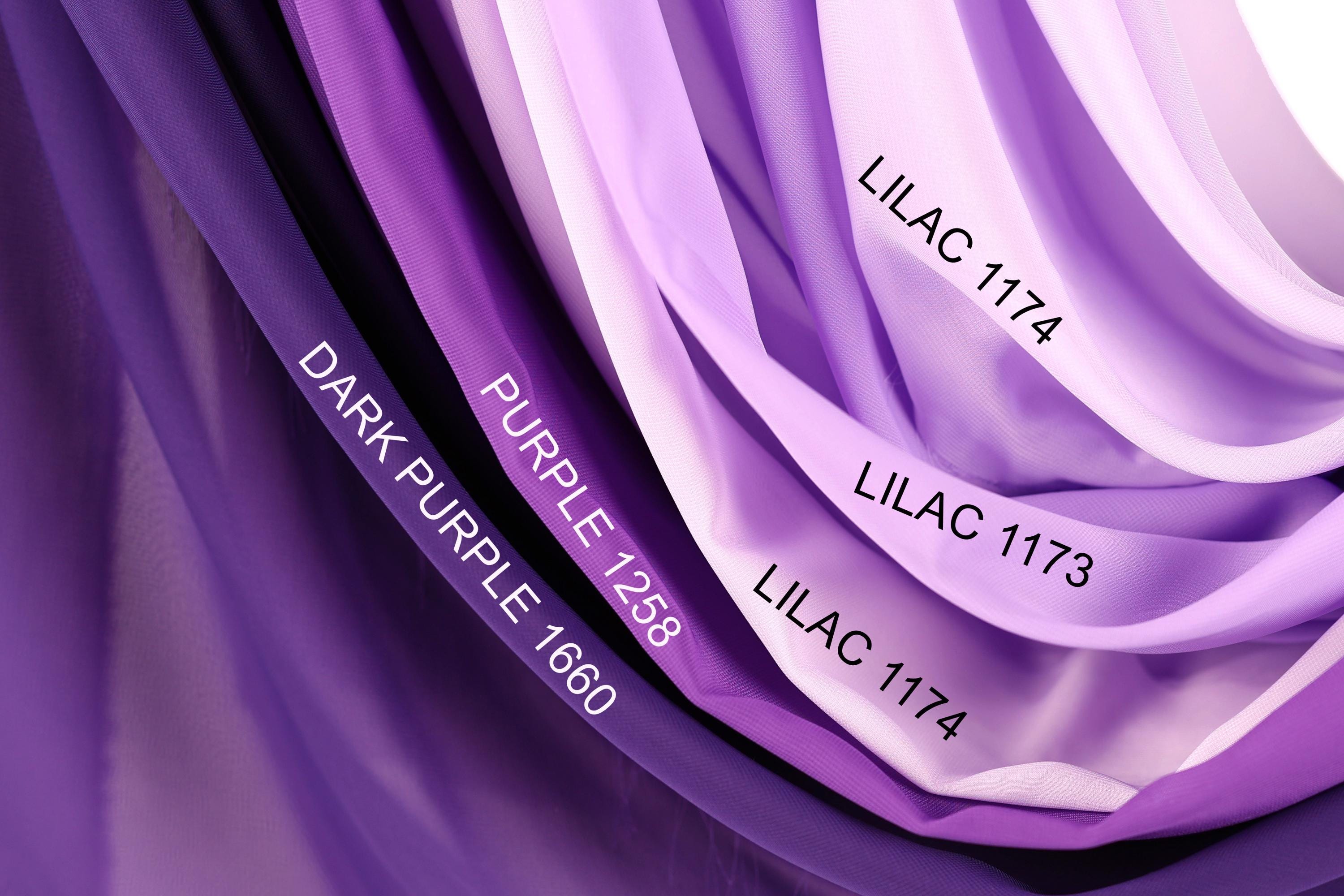 a close-up view of a fabric with various shades of purple, including dark purple, purple, and lavender. The fabric appears to be a sheer material, with the colors transitioning smoothly from one shade to another.