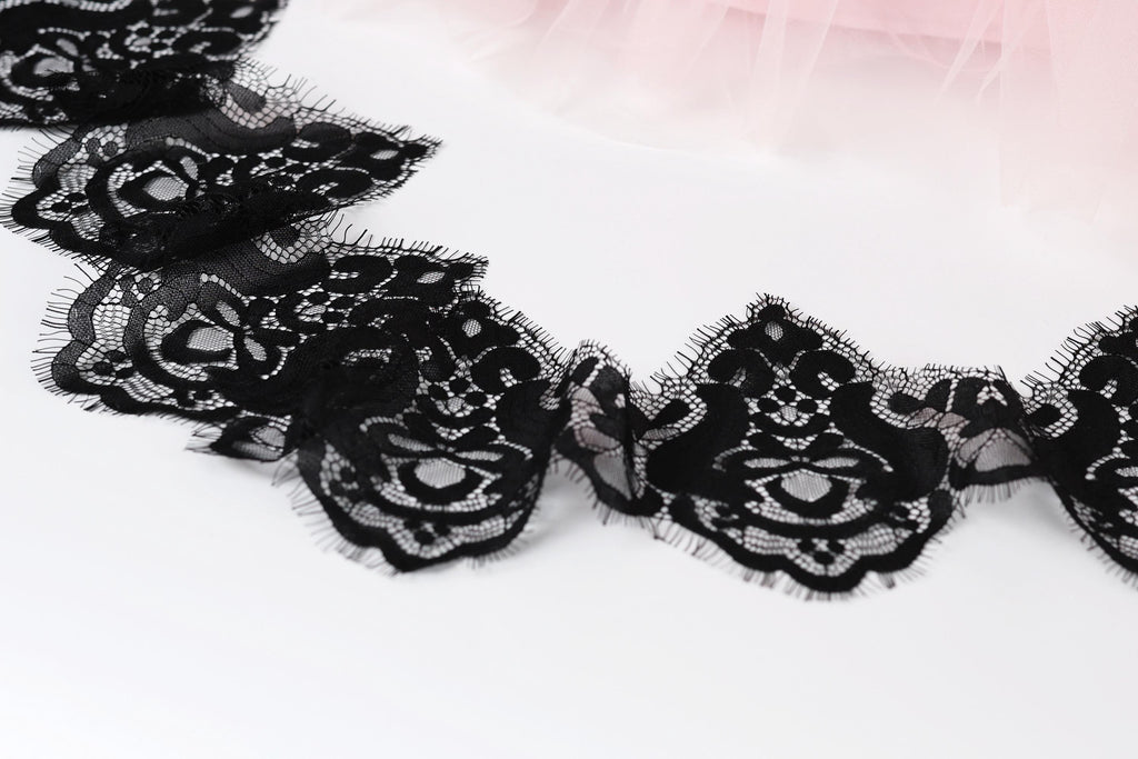 a close-up view of a delicate black lace trim with intricate floral patterns.