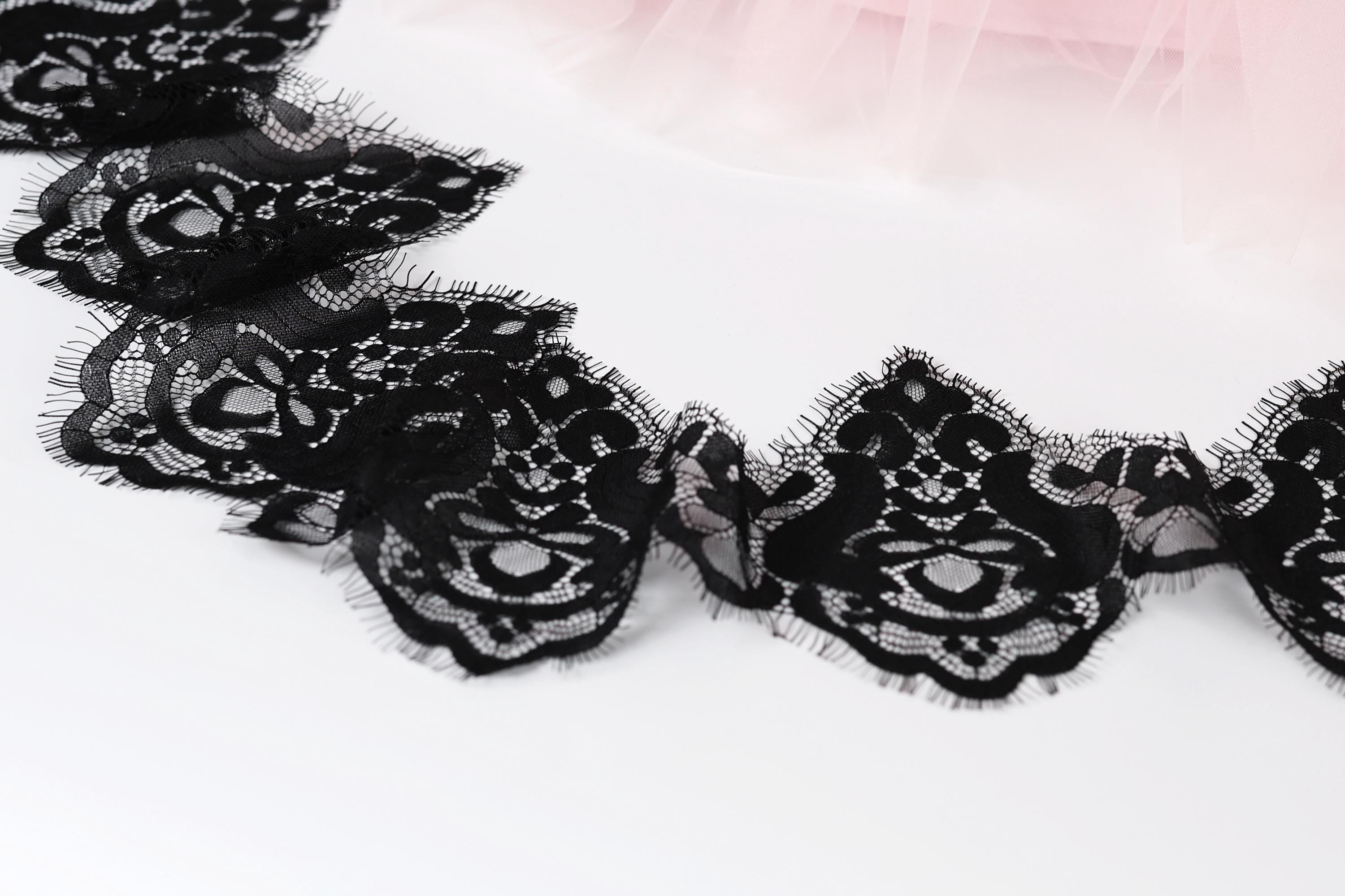 a close-up view of a delicate black lace trim with intricate floral patterns.