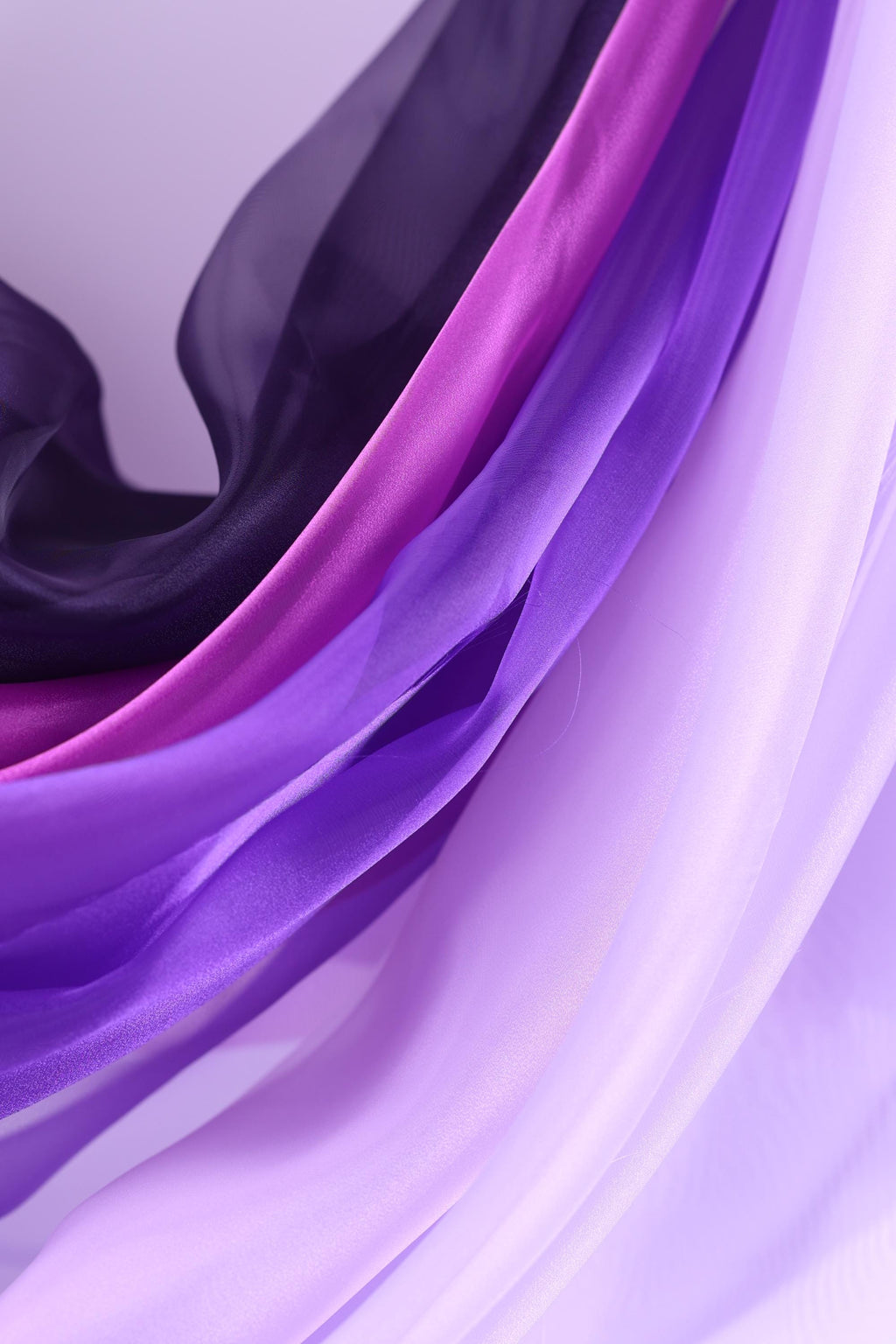 a close-up view of a fabric with a purple and pink color scheme, with the fabric appearing to be made of silk or a similar material.