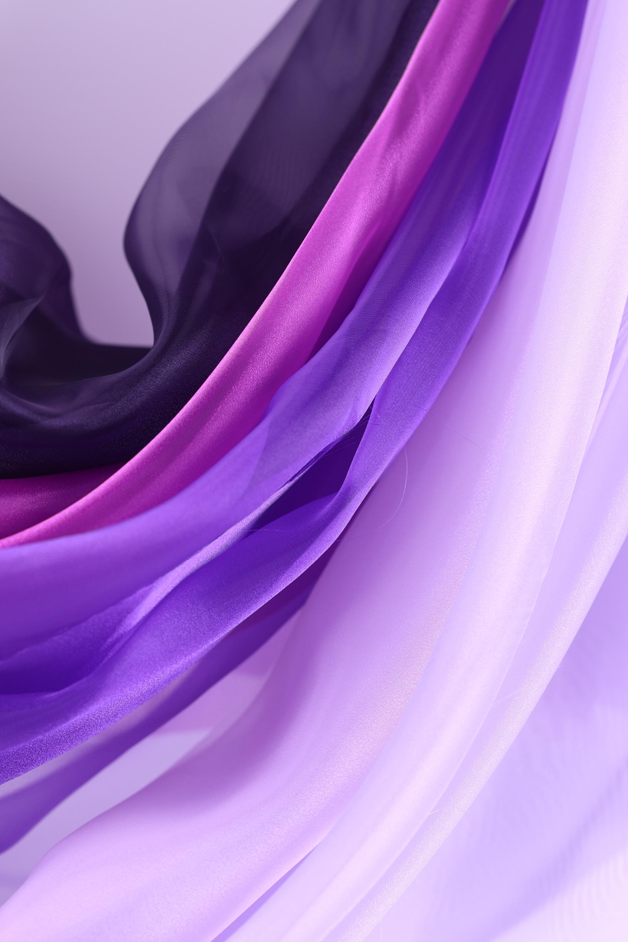 a close-up view of a fabric with a purple and pink color scheme, with the fabric appearing to be made of silk or a similar material.