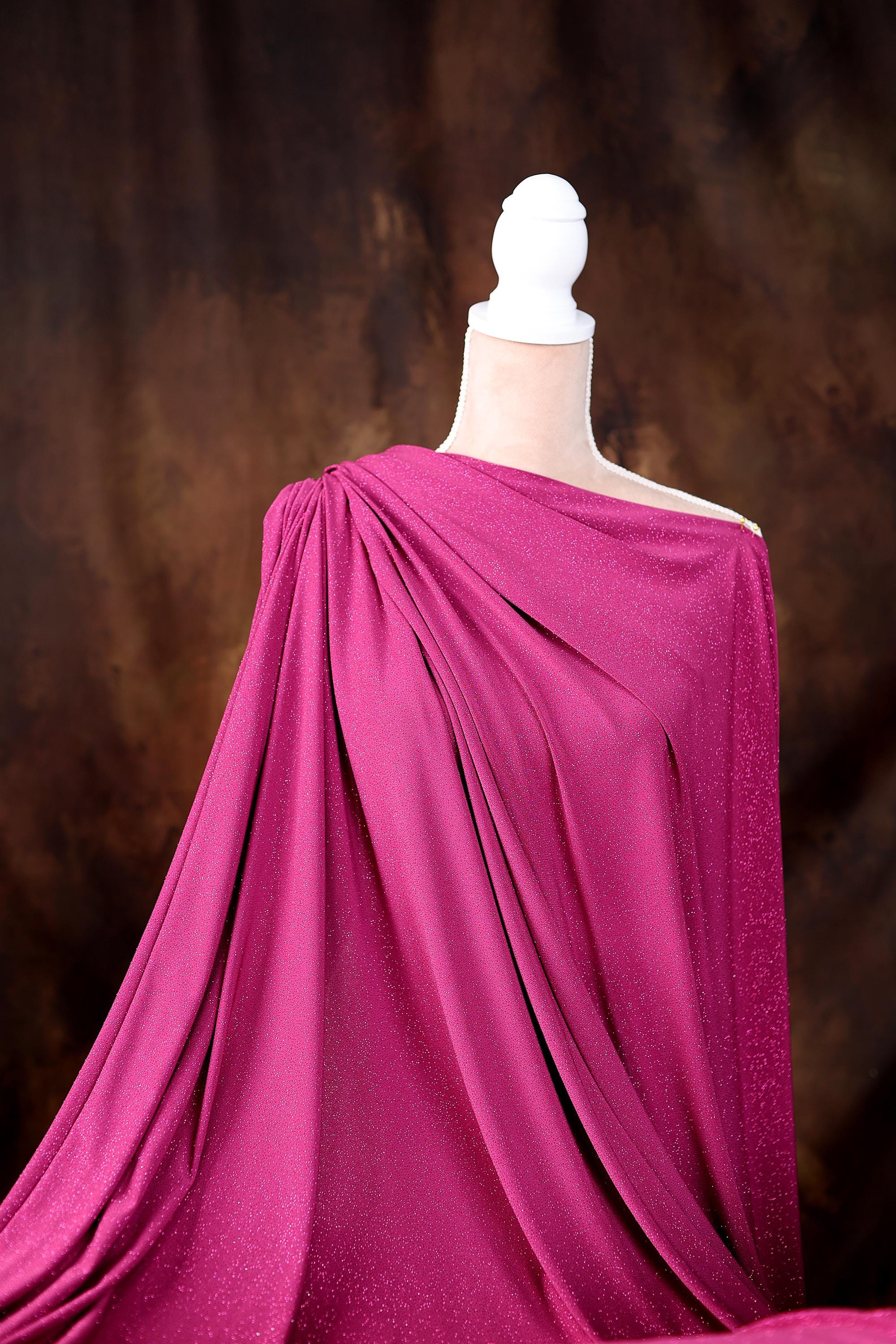 a mannequin wearing a pink draped dress