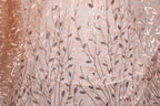 a close-up view of a fabric with a repeating pattern of leaves and branches, creating a textured and visually appealing design.