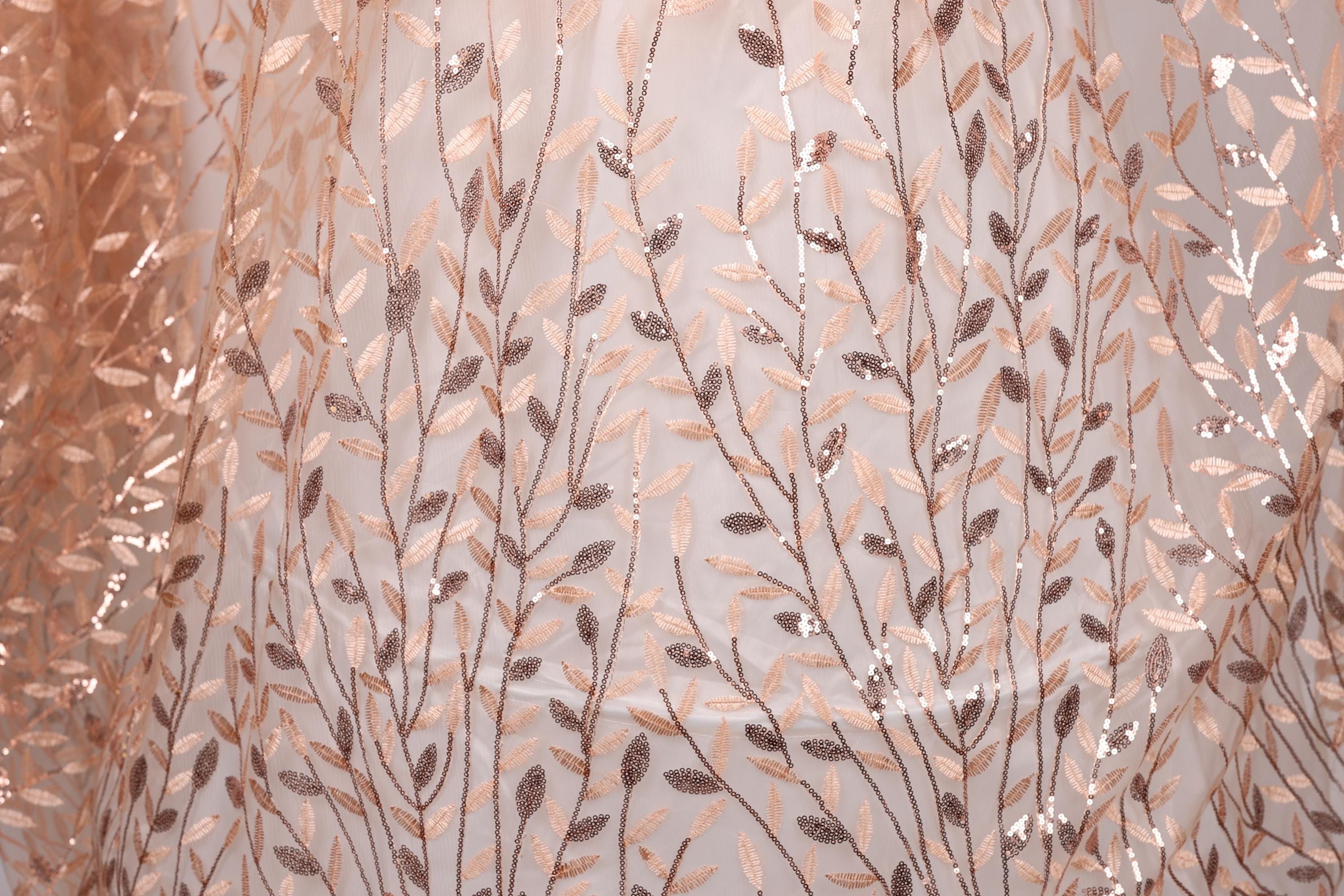 a close-up view of a fabric with a repeating pattern of leaves and branches, creating a textured and visually appealing design.