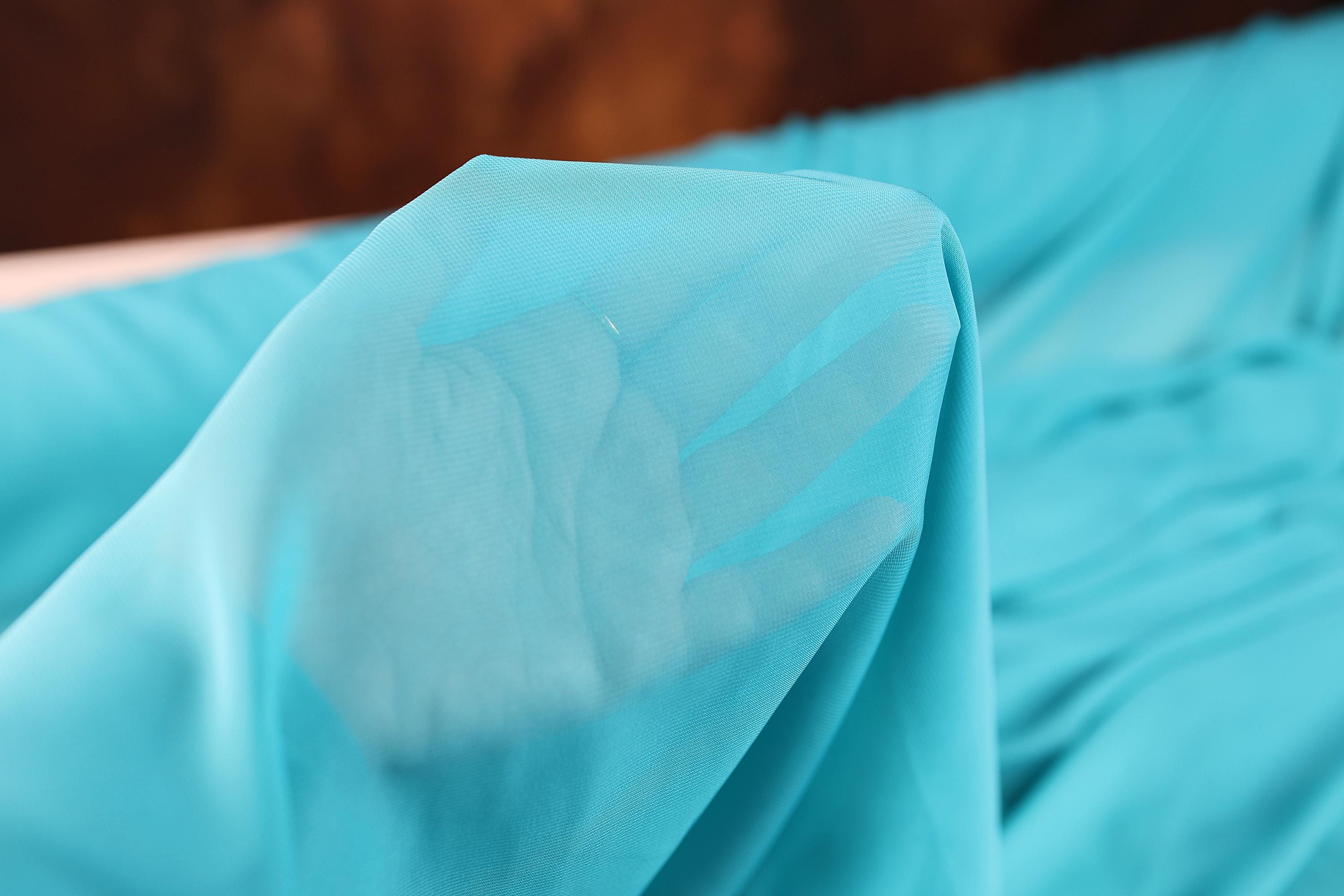 a close up of a blue sheet on a bed
