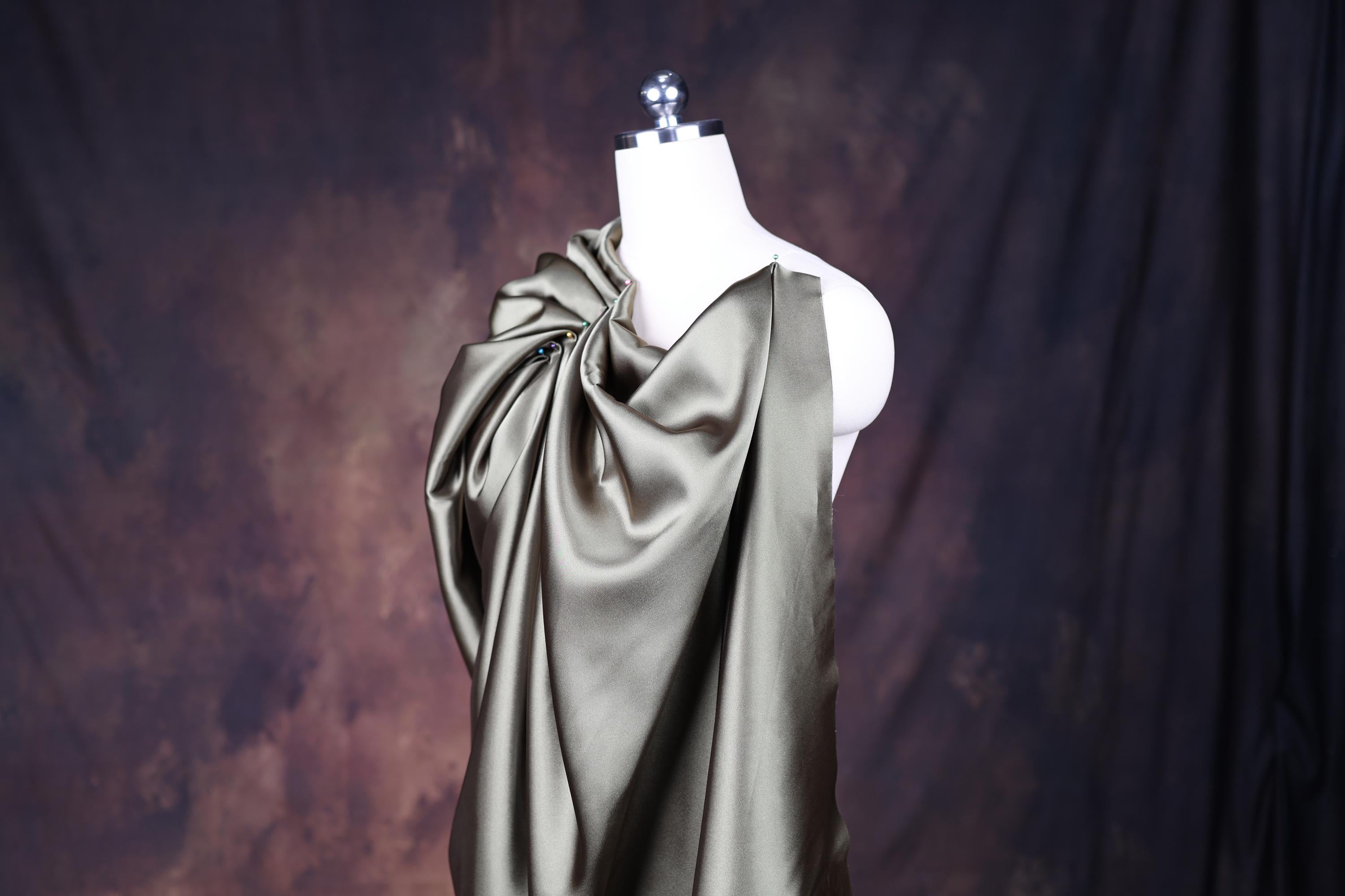 a white mannequin wearing a gray dress