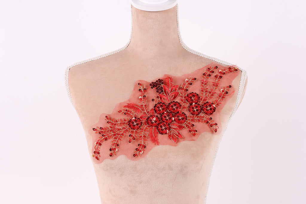 A mannequin with a red floral embroidered on its chest.