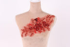 A mannequin with a red floral embroidered on its chest.
