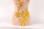 a mannequin with a beige body and a floral design on its side, including yellow flowers and leaves.