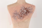 a mannequin with a pink fabric adorned with a floral design, including roses and leaves.