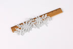 A wooden ruler with a decorative floral lace trim placed on it.