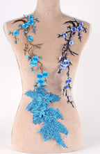 A mannequin torso with blue and purple floral embroidery on it.