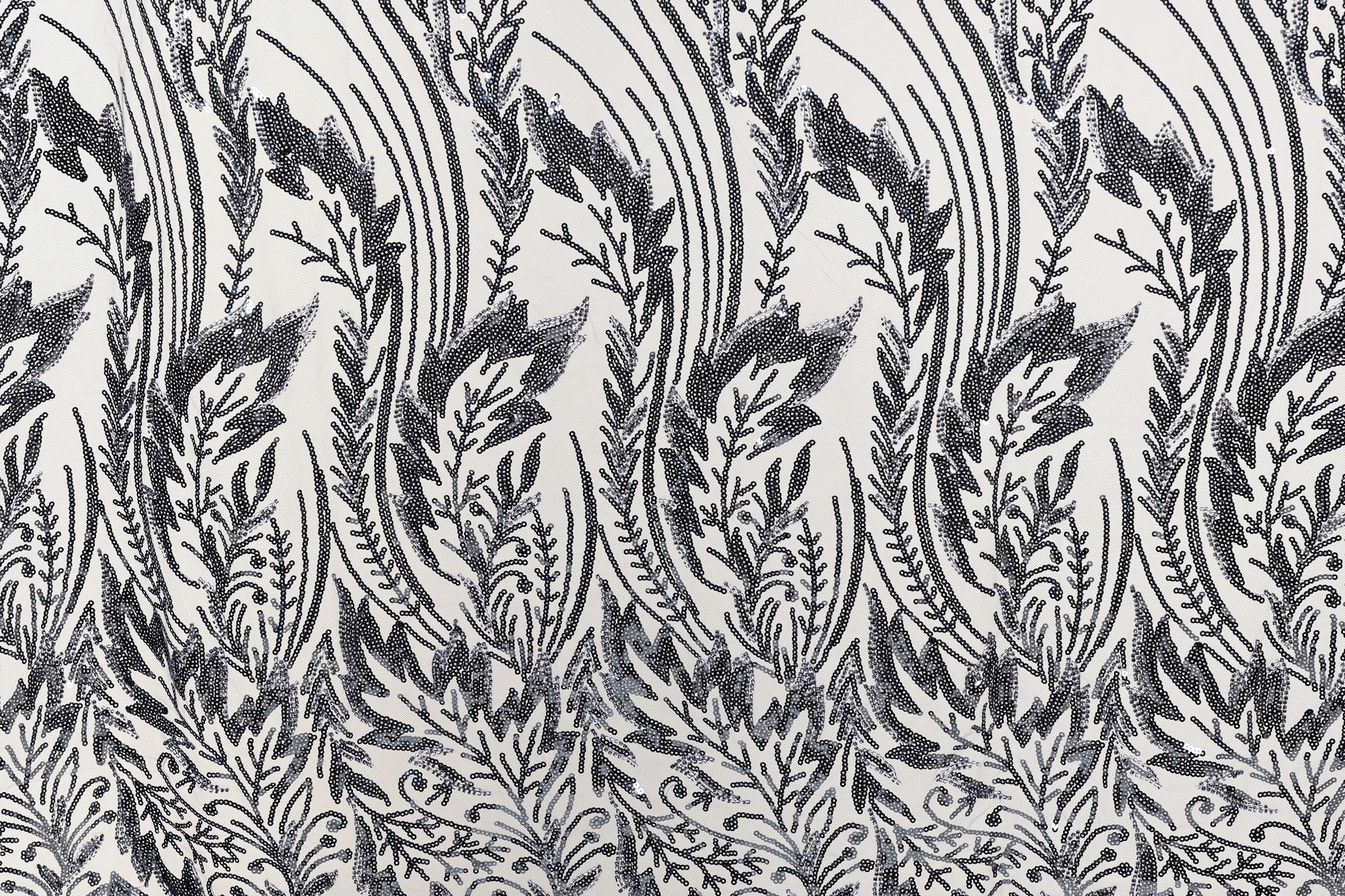 a repeating pattern of black and white floral designs on a fabric surface.