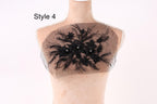 A mannequin with a decorative black lace design on its chest area, featuring a floral pattern.