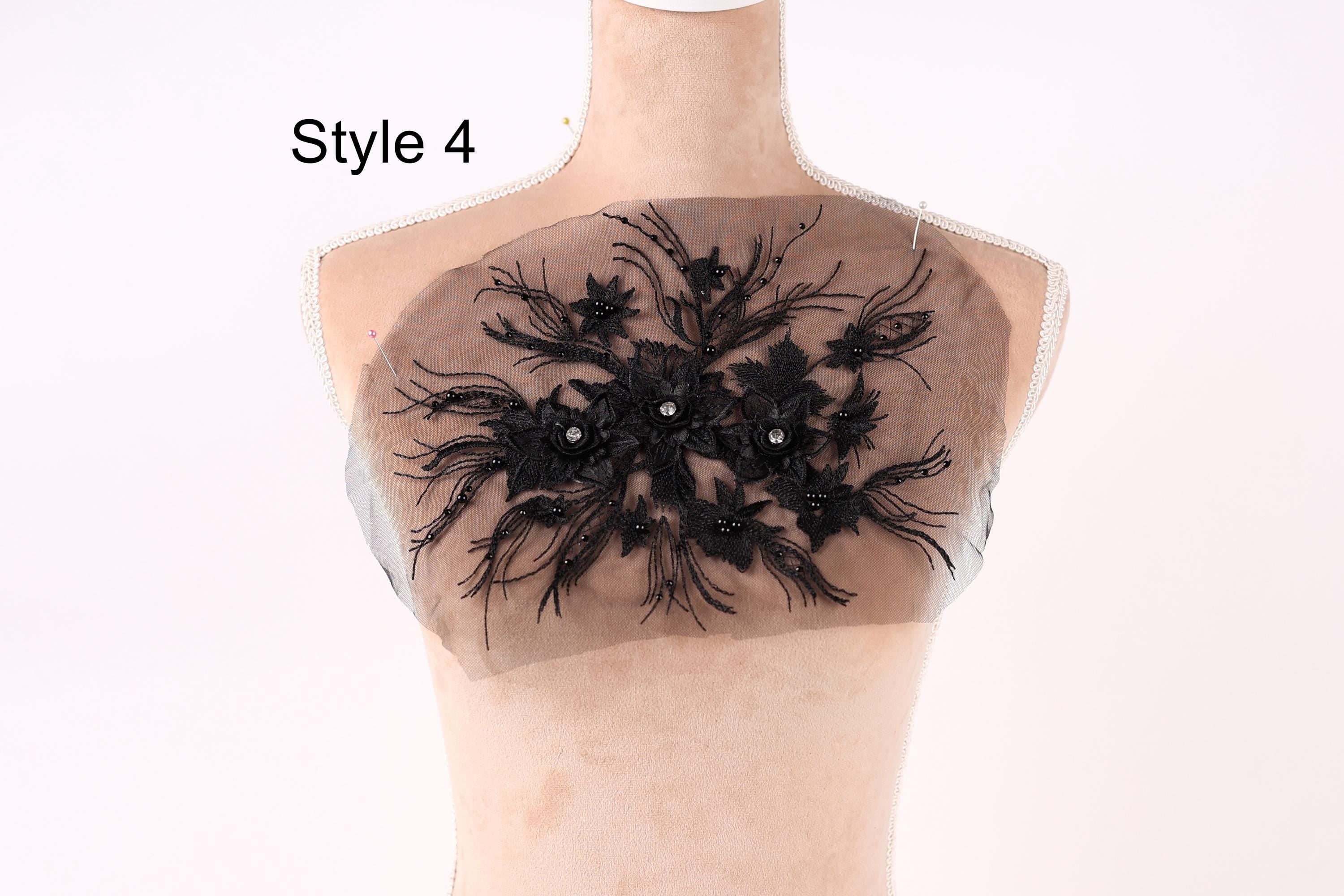 A mannequin with a decorative black lace design on its chest area, featuring a floral pattern.