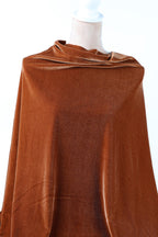 a close-up view of a brown fabric, possibly velvet, with a crumpled appearance.