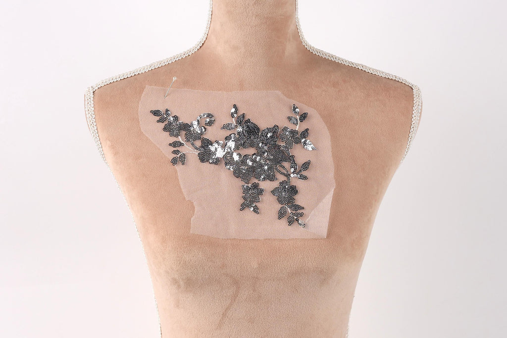 a mannequin torso with a piece of fabric or material attached to it, featuring a floral pattern.