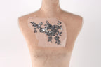 a mannequin torso with a piece of fabric or material attached to it, featuring a floral pattern.