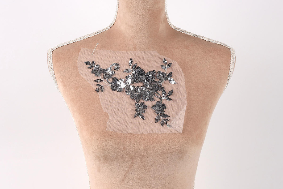 a mannequin torso with a piece of fabric or material attached to it, featuring a floral pattern.