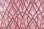 a close-up view of a pink fabric with a repeating pattern of black and pink lines and dots, creating a visually striking and intricate design.