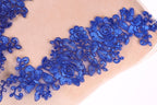 a close-up view of a fabric with a delicate blue floral embroidery design.