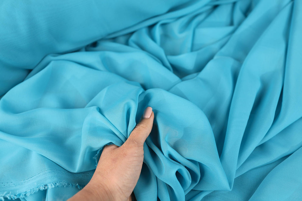 a person&#39;s hand on a blue cloth