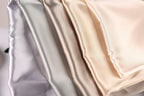 A close-up image of a fabric with a gradient of colors, ranging from light to dark shades of gray, beige, and off-white.