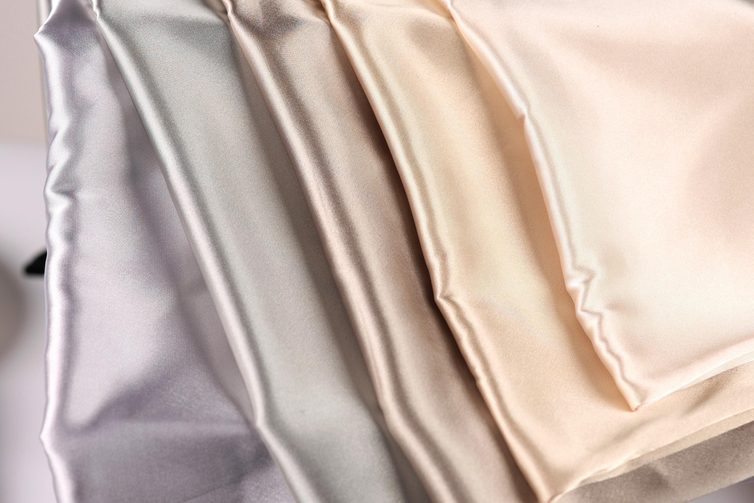 A close-up image of a fabric with a gradient of colors, ranging from light to dark shades of gray, beige, and off-white.
