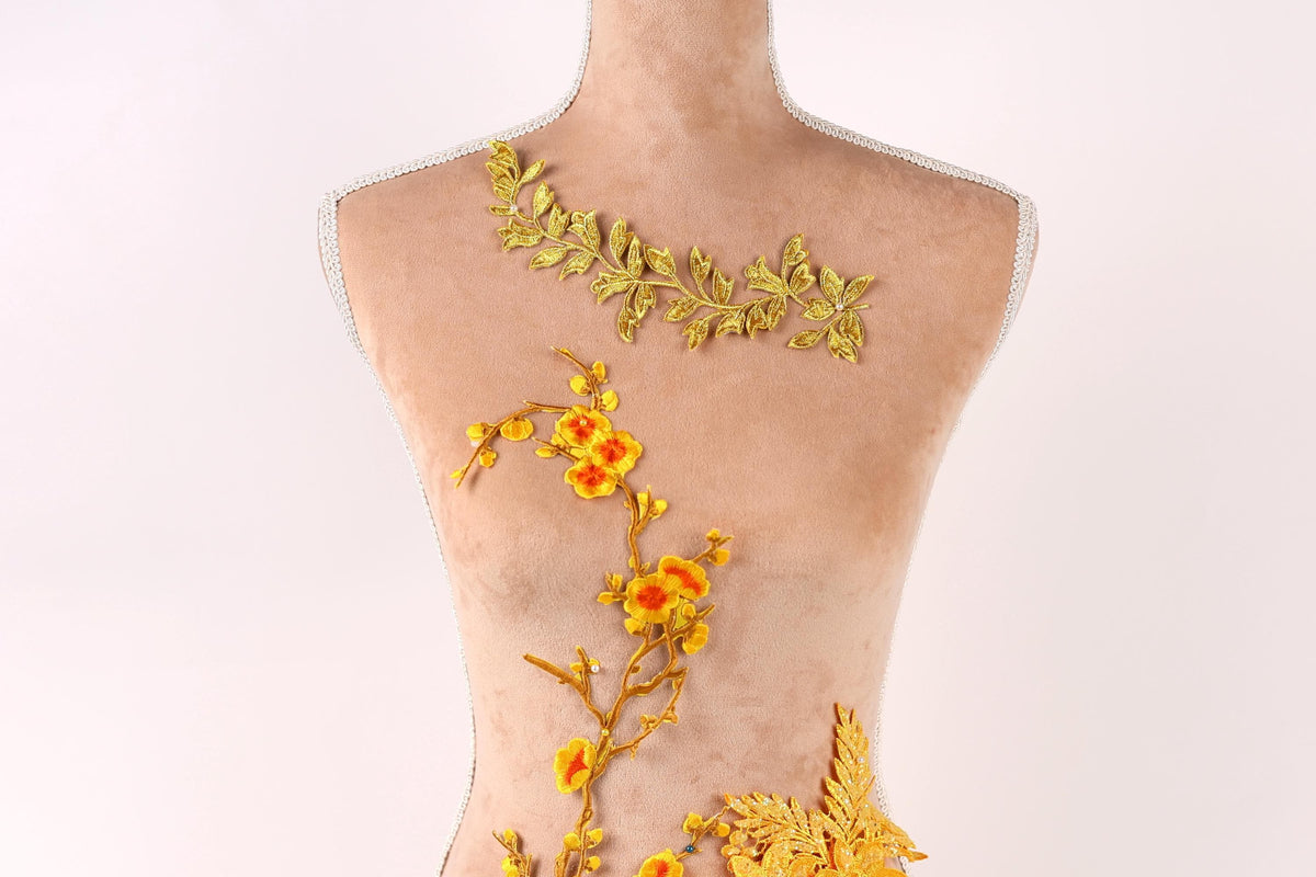 A mannequin with a floral design on its torso, featuring yellow flowers and leaves.