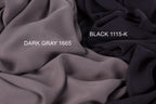 two different fabric swatches, one dark gray and one black, with the dark gray fabric labeled as "Dark Gray 1665" and the black fabric labeled as "Black 1115-K".