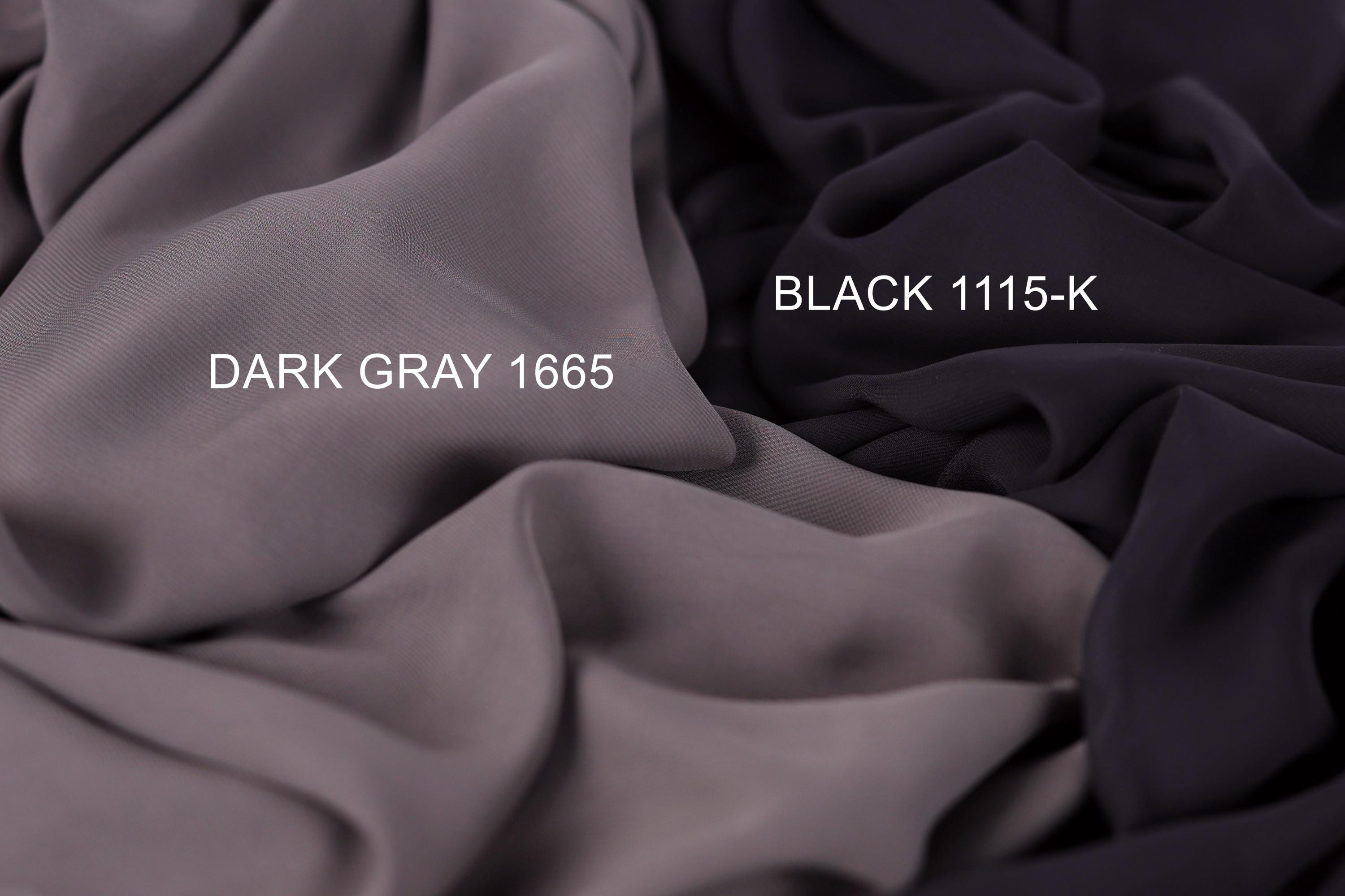 two different fabric swatches, one dark gray and one black, with the dark gray fabric labeled as "Dark Gray 1665" and the black fabric labeled as "Black 1115-K".
