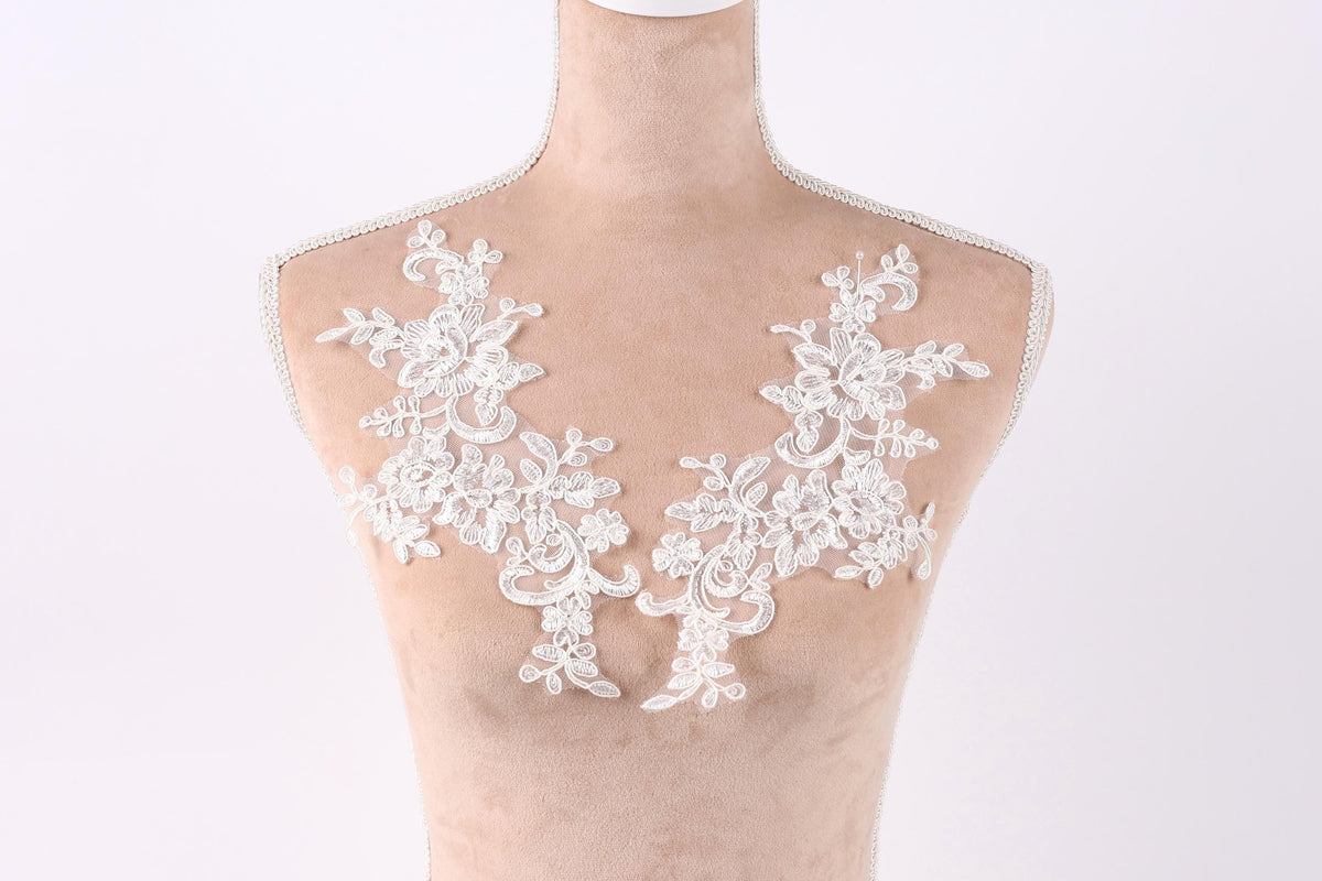 A mannequin with a white lace bodice and floral embroidery on the bust area.