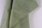 a close-up view of a fabric with a striped pattern in shades of green and yellow.