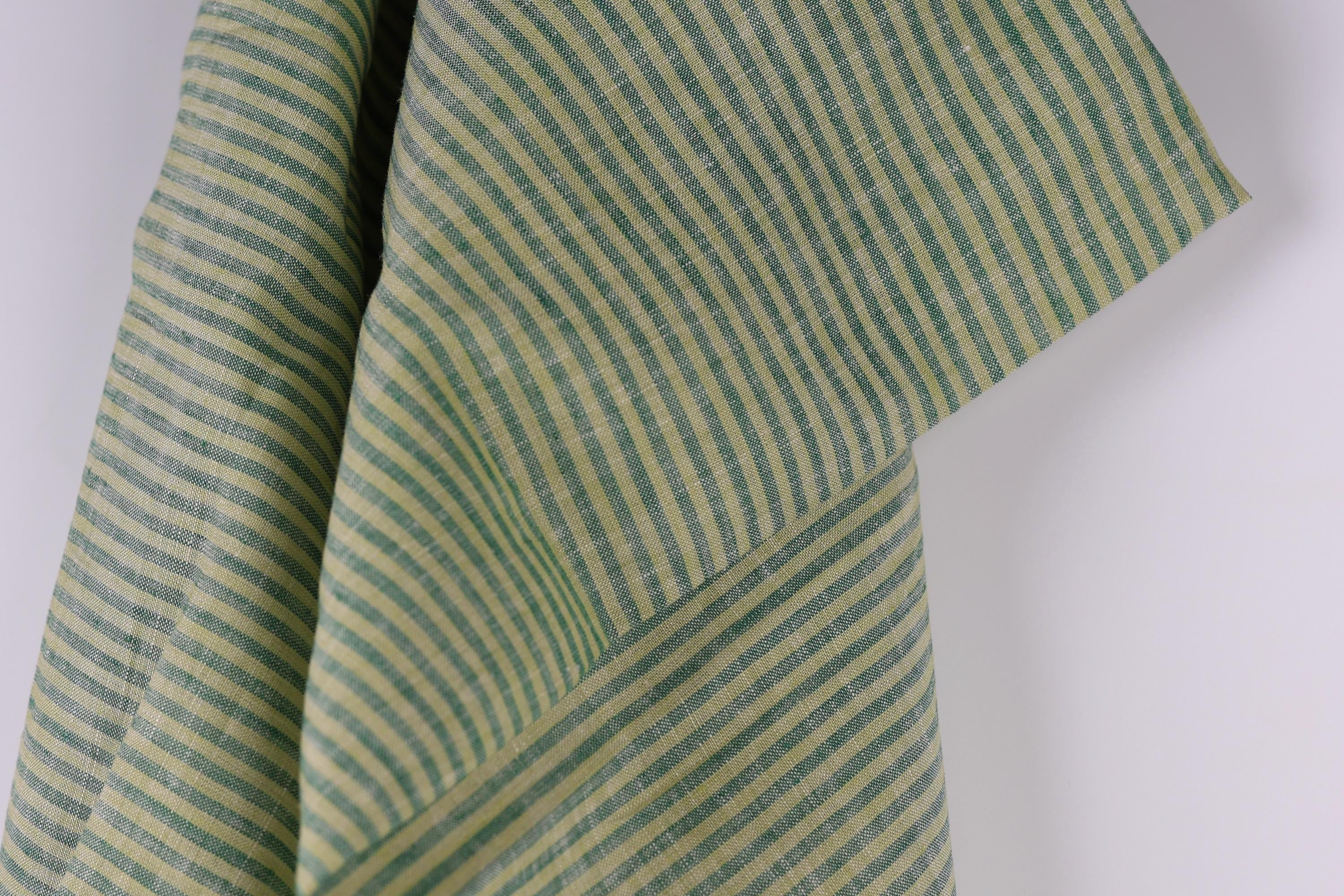 a close-up view of a fabric with a striped pattern in shades of green and yellow.