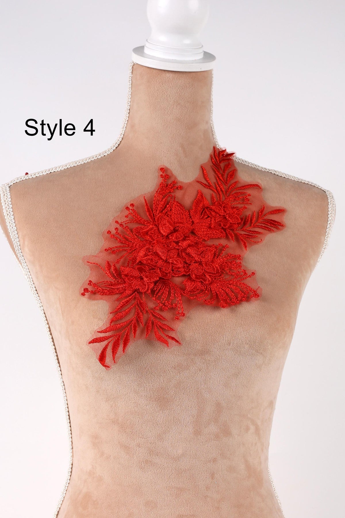 A mannequin with a red floral embroidered on its bust, displayed against a white background.